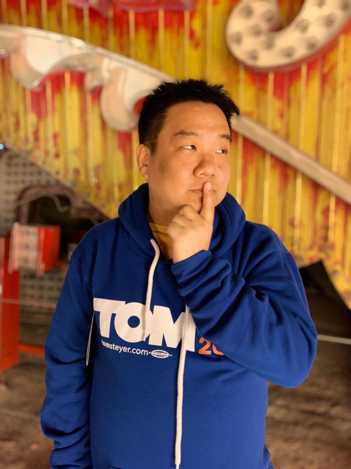 Tony Choi poses in a Tom Steyer 2020 sweatshirt.